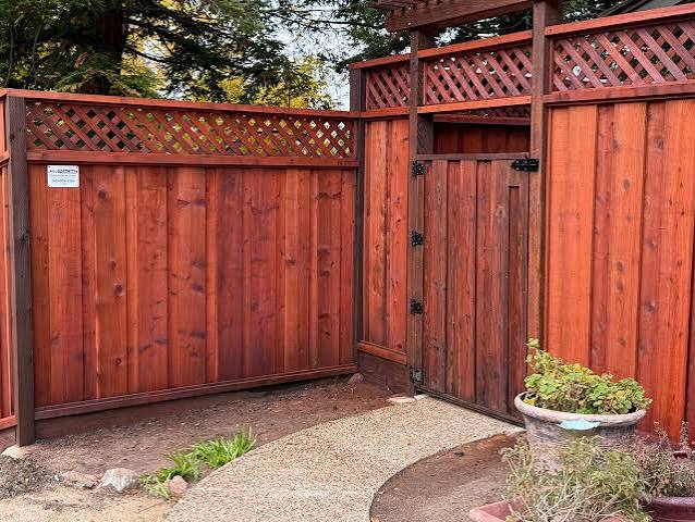 Privacy fence and gate sealed in a uniform redwood finish