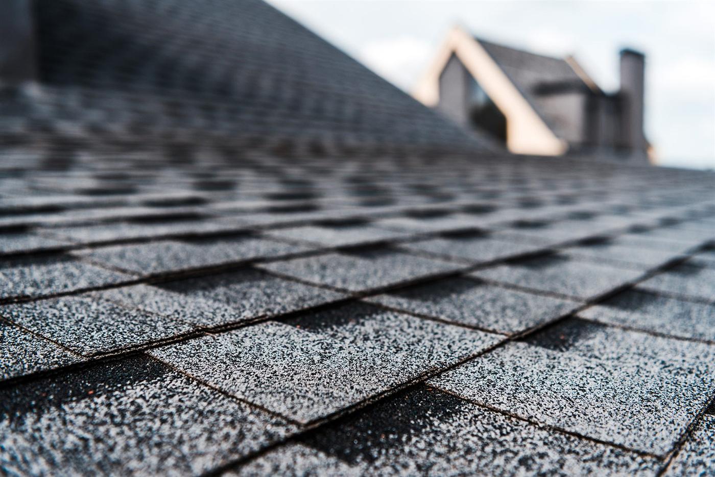 Close view of coated asphalt shingles with granules bonded in place